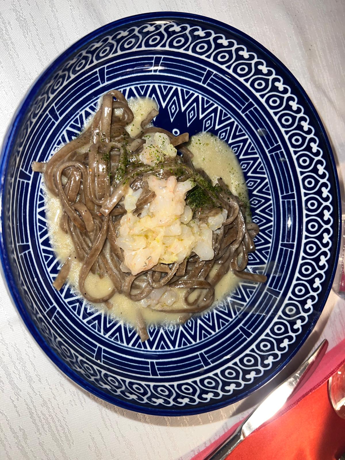 Seafood pasta on a blue patterned plate